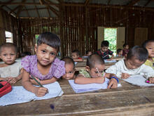 Refugee children hold pencils in a classroom at a refugee camp in northern Thailand