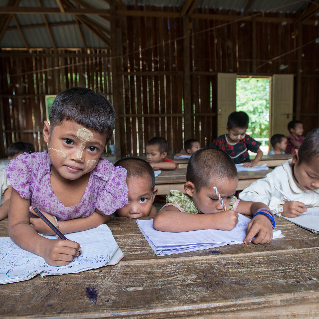 Refugee children hold pencils in a classroom at a refugee camp in northern Thailand