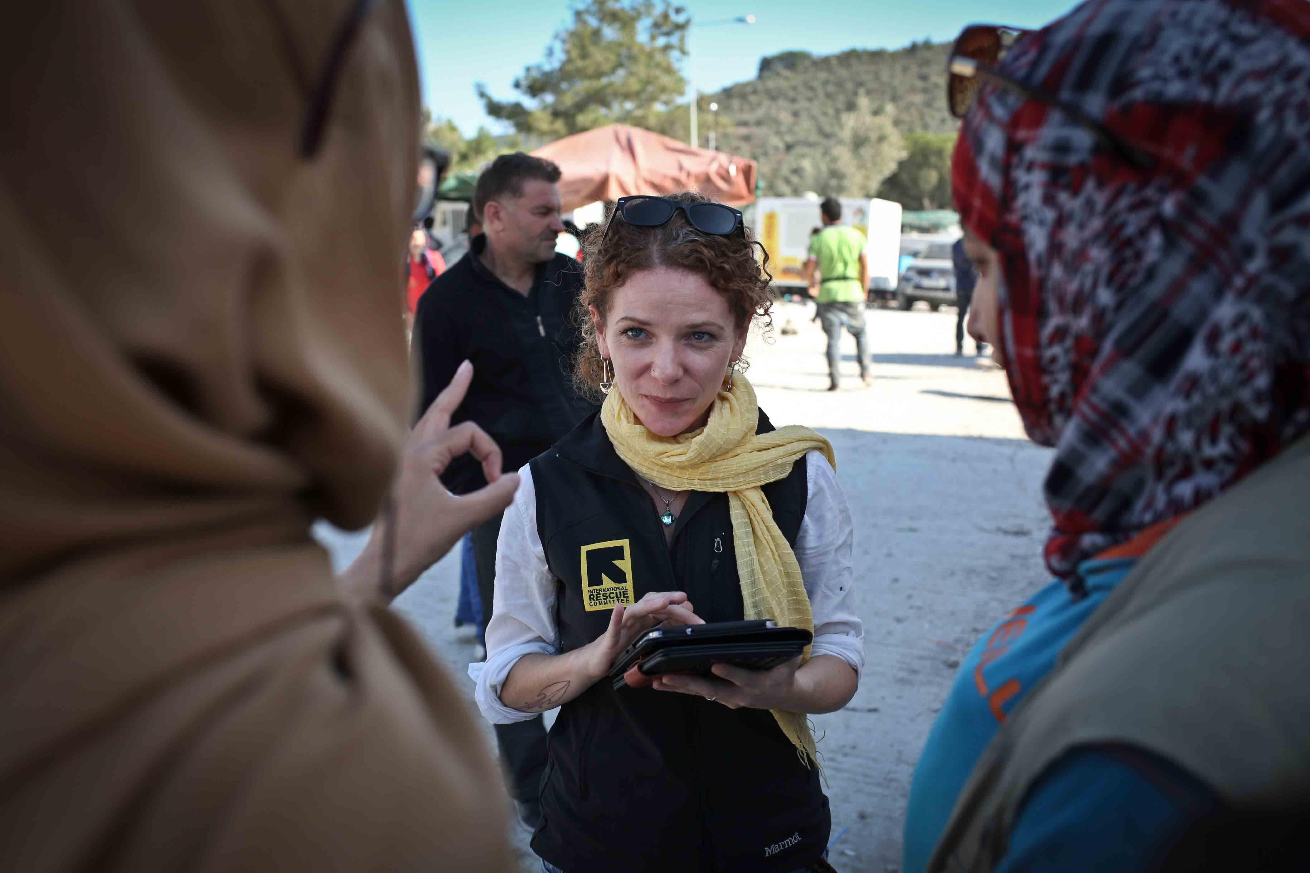 an IRC employee taking notes while talking to two women