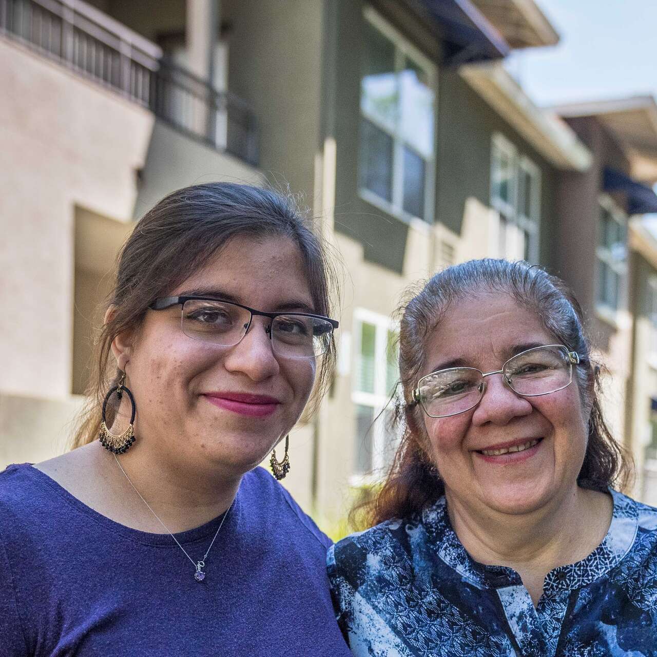 Two women stand next to each and pose for a picture.