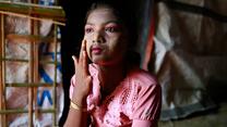 Hasina, applying traditional make-up to her face