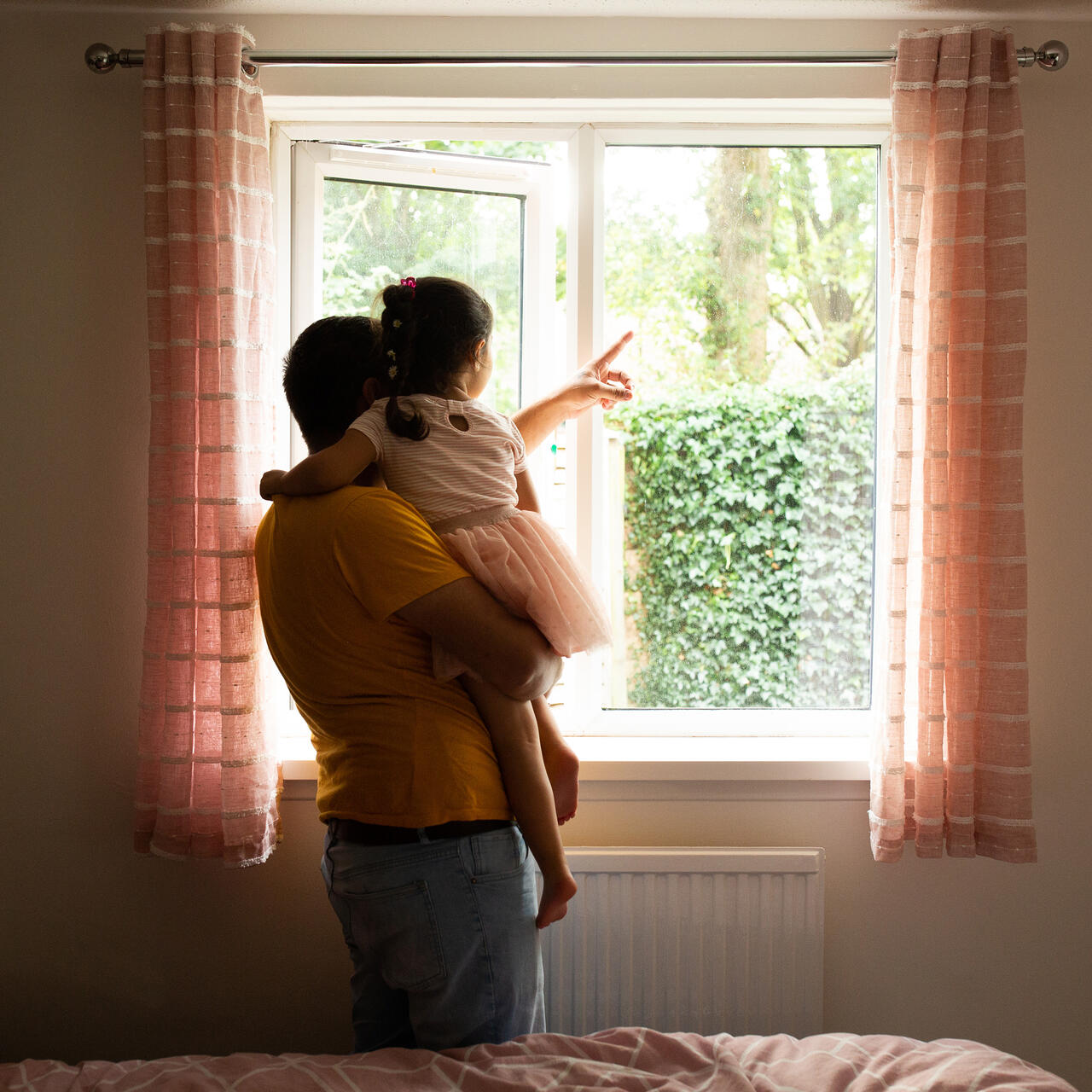 Man and child by window