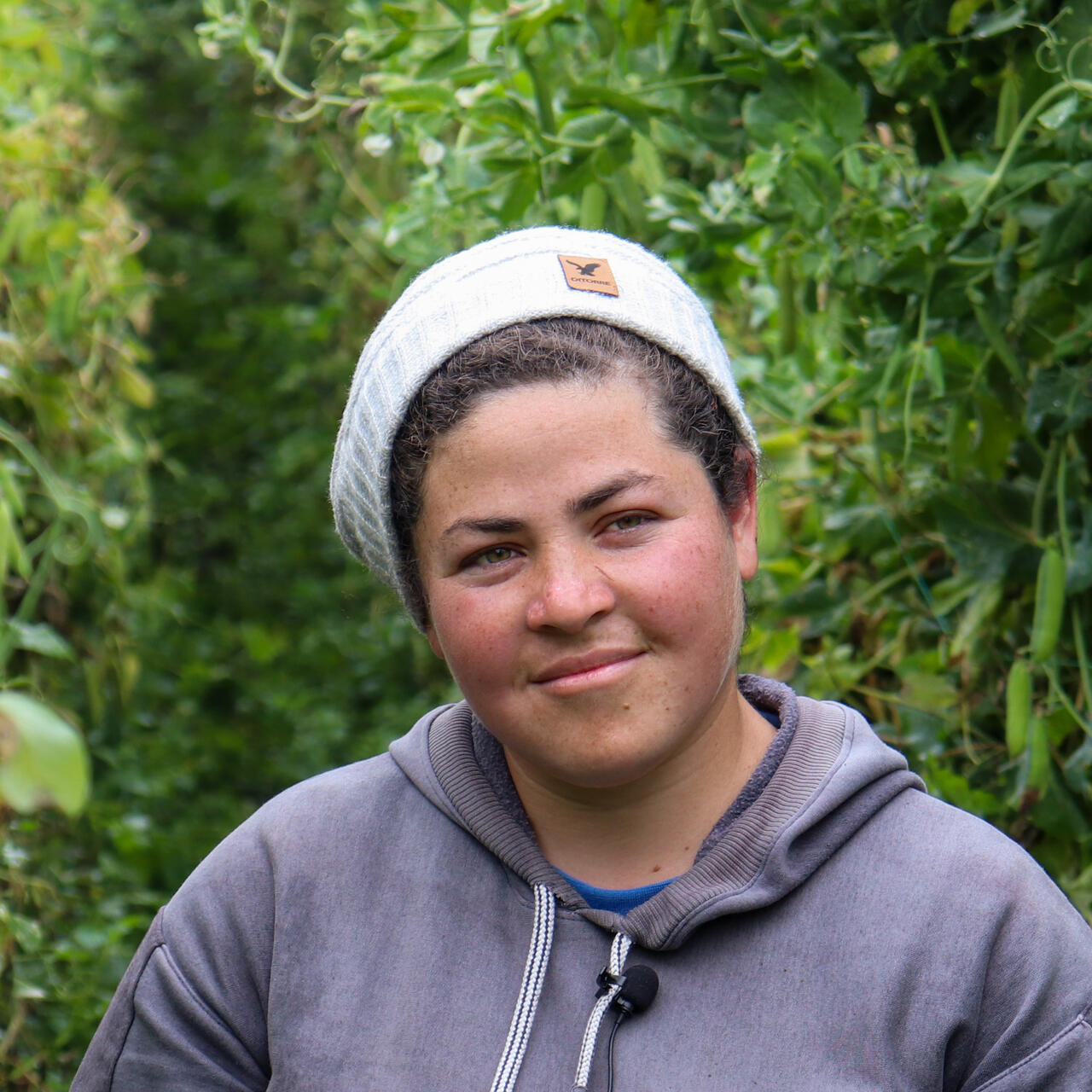 A woman poses for a portrait in a field.