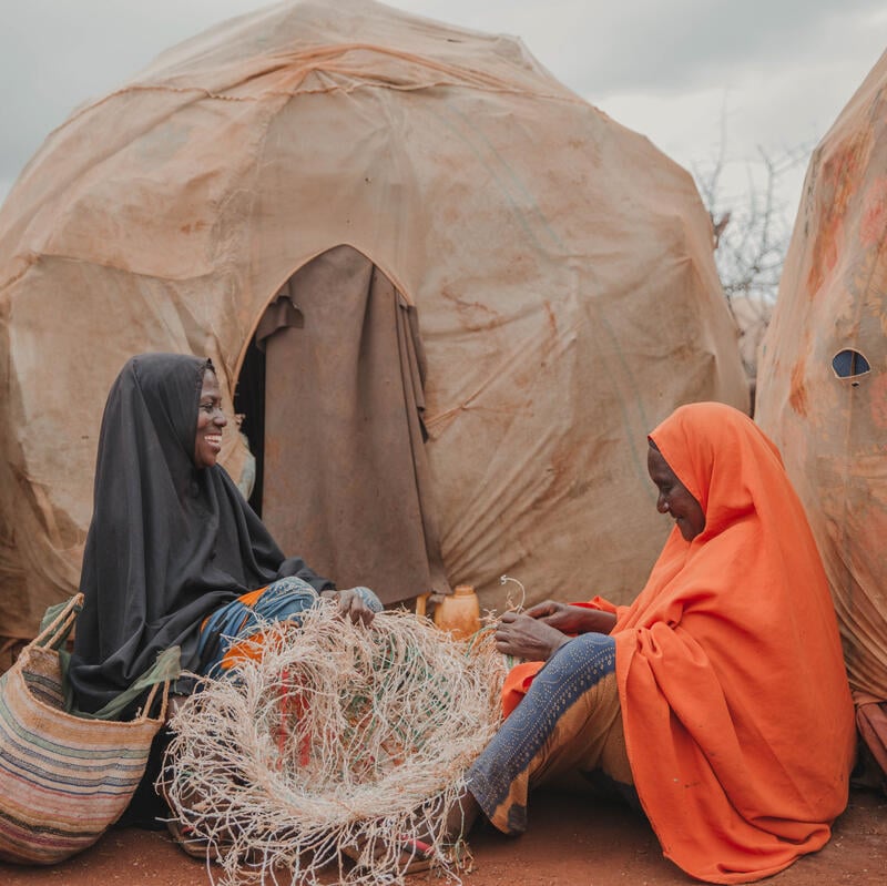 Nunay and Bigisow sat in front of their tents, making baskets.