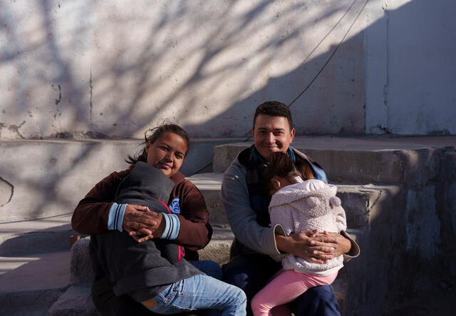 Natalia and José hold their two children. 