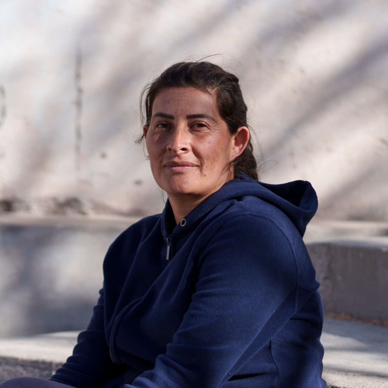 A woman poses for a photo while sitting on stairs.