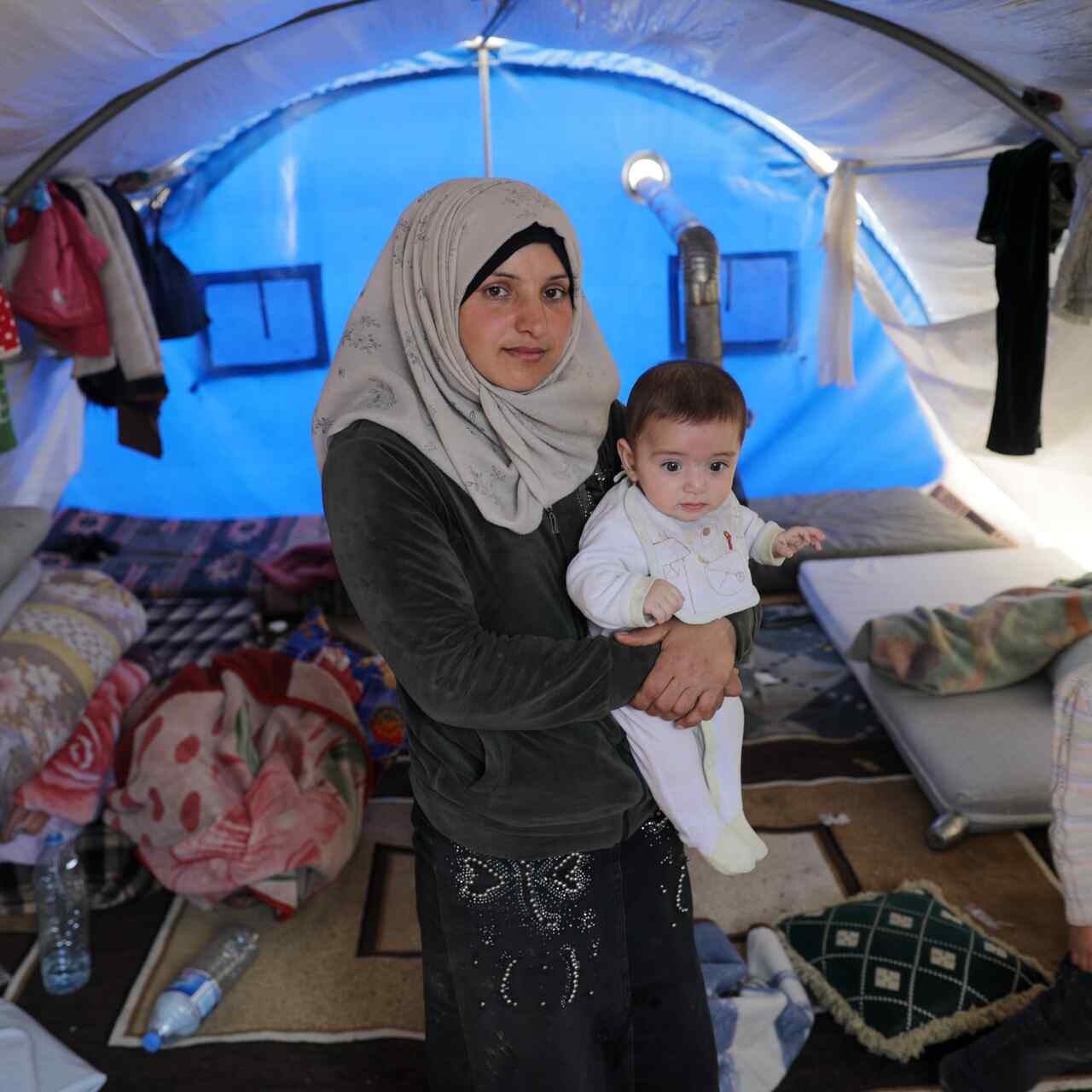 A mother holds her child at a shelter in Syria.