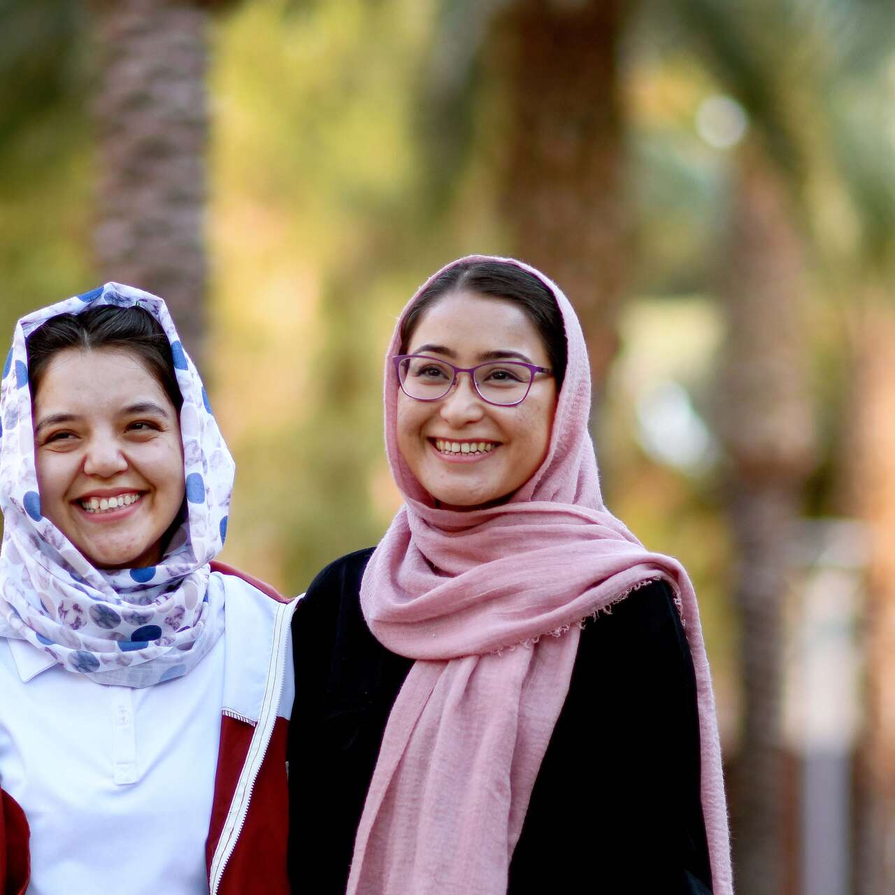 Two young women smile together and pose for a photo.