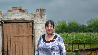 A woman stands outsider her home in Ukraine.