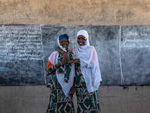 Two women stand together at the front of a classroom in Chad.