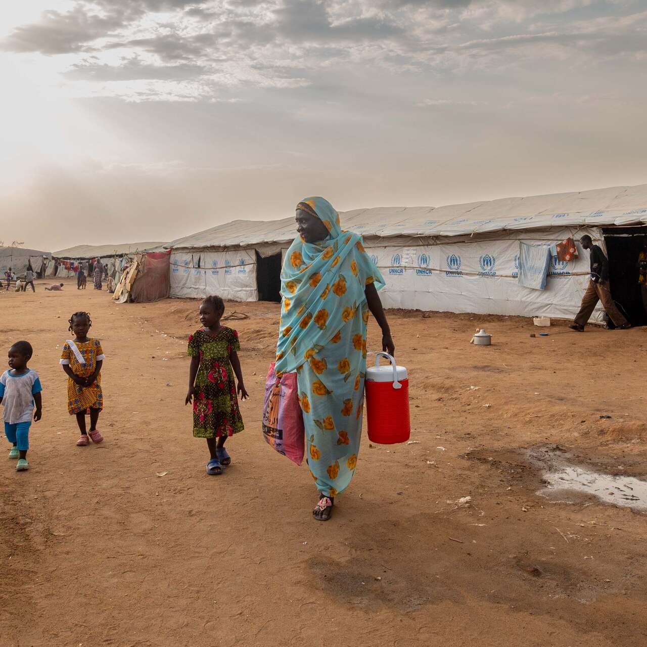 Fairuz stands outside the camp with her grandchildren.