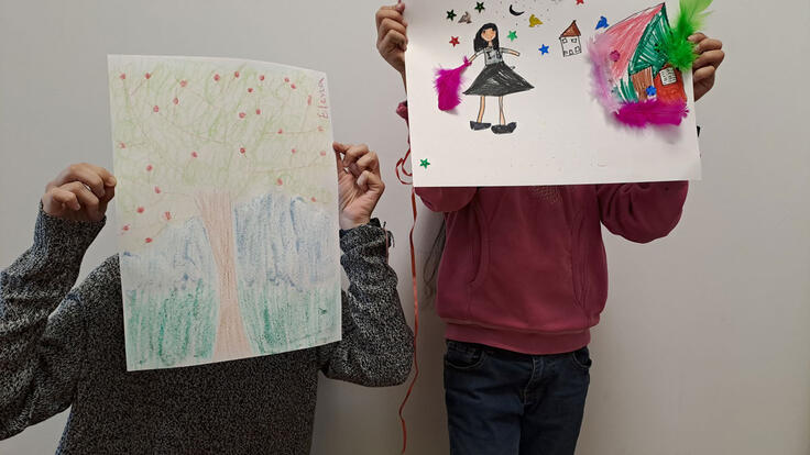 Karima's children holding drawings