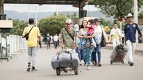 people crossing a border and carrying stuff