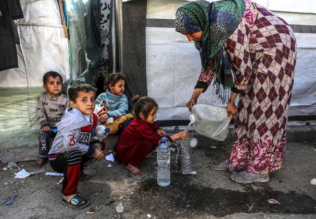 Children queue to receive water in Rafah, Gaza.