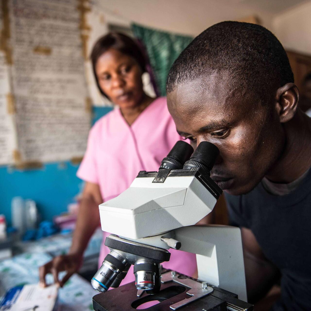 A man looking through an Microscope