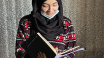 Portrait of Lina looking down, holding a book