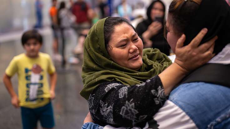 A mother holds her daughters cheeks and begins to cry tears of joy.