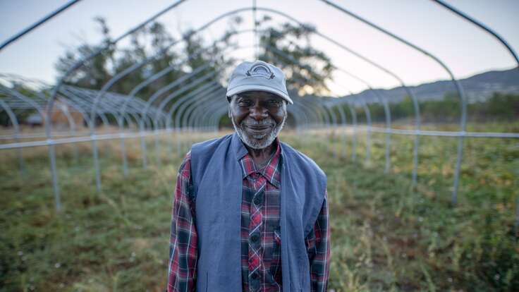 Portrait of Omar, a refugee from Sudan, standing in front of his farm in Salt Lake City, Utah.