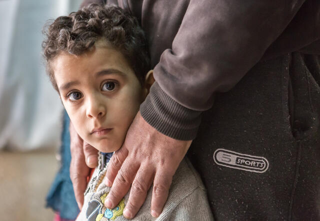 Parent holding son's shoulders.