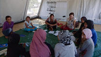 Refugee girls play games in a tent that serves as an IRC "safe space" in a camp in Greece 