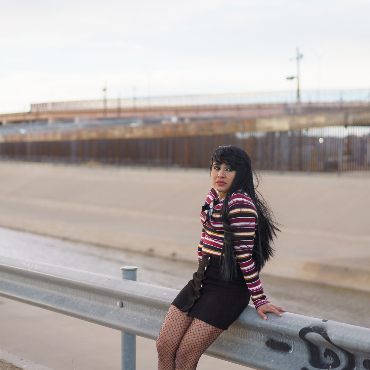 Fernanda stands by a rail at the US-Mexico border